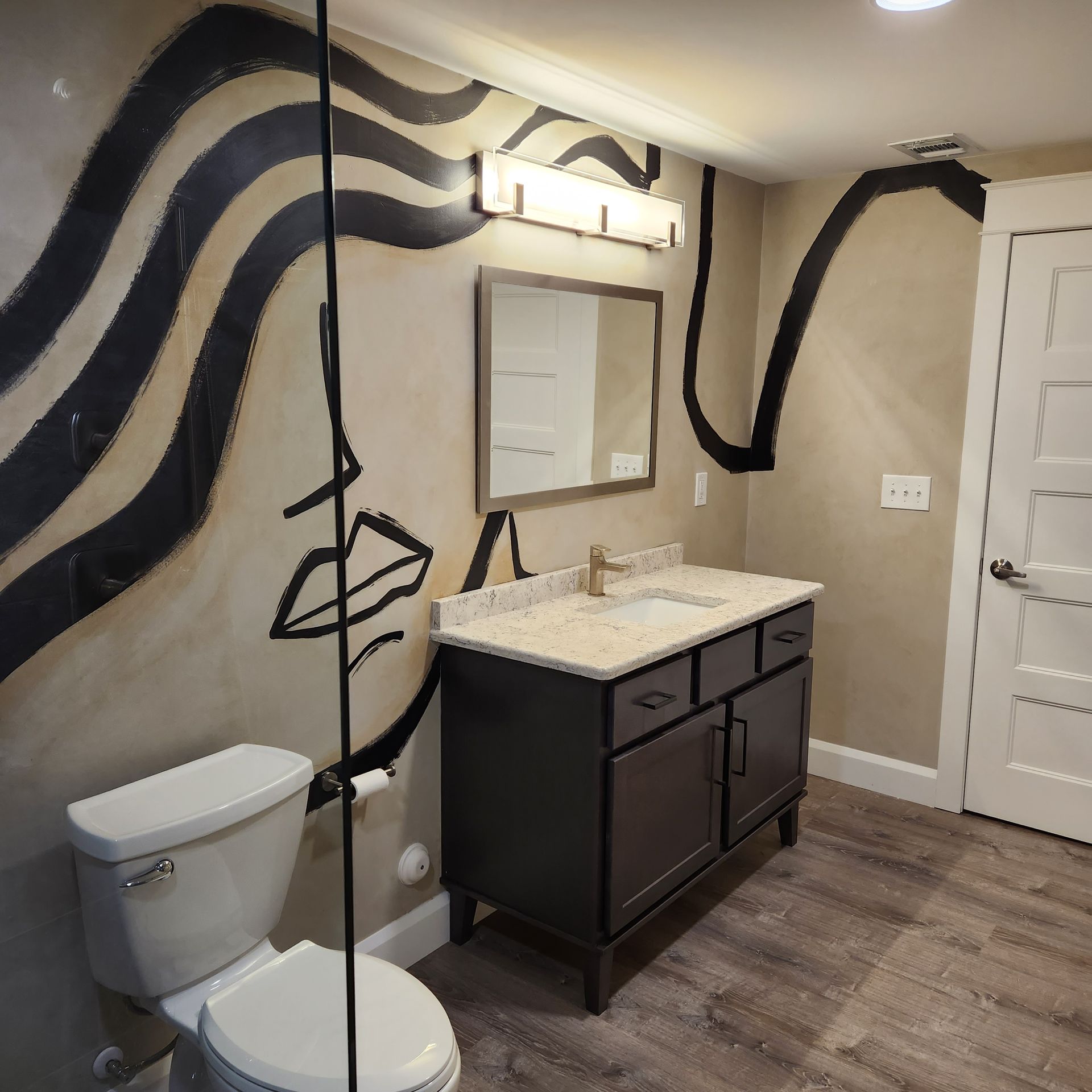 A bathroom with a toilet a sink and a mirror