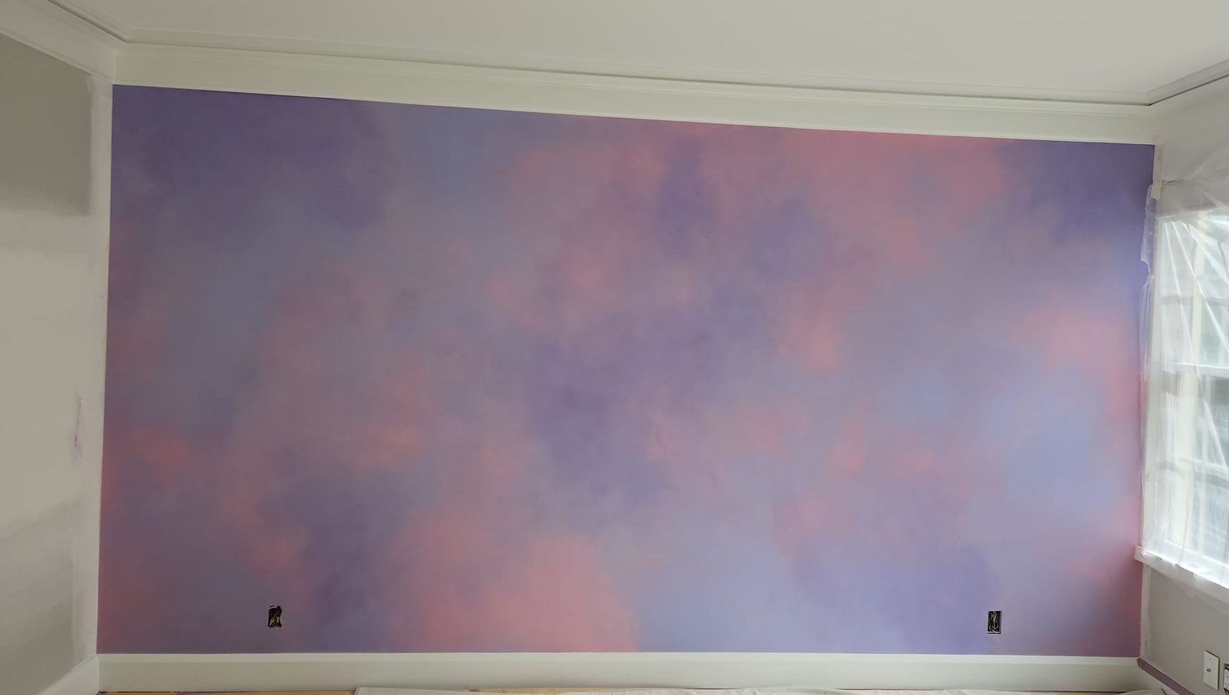 A purple and pink wall in a room with a window. artist kids room