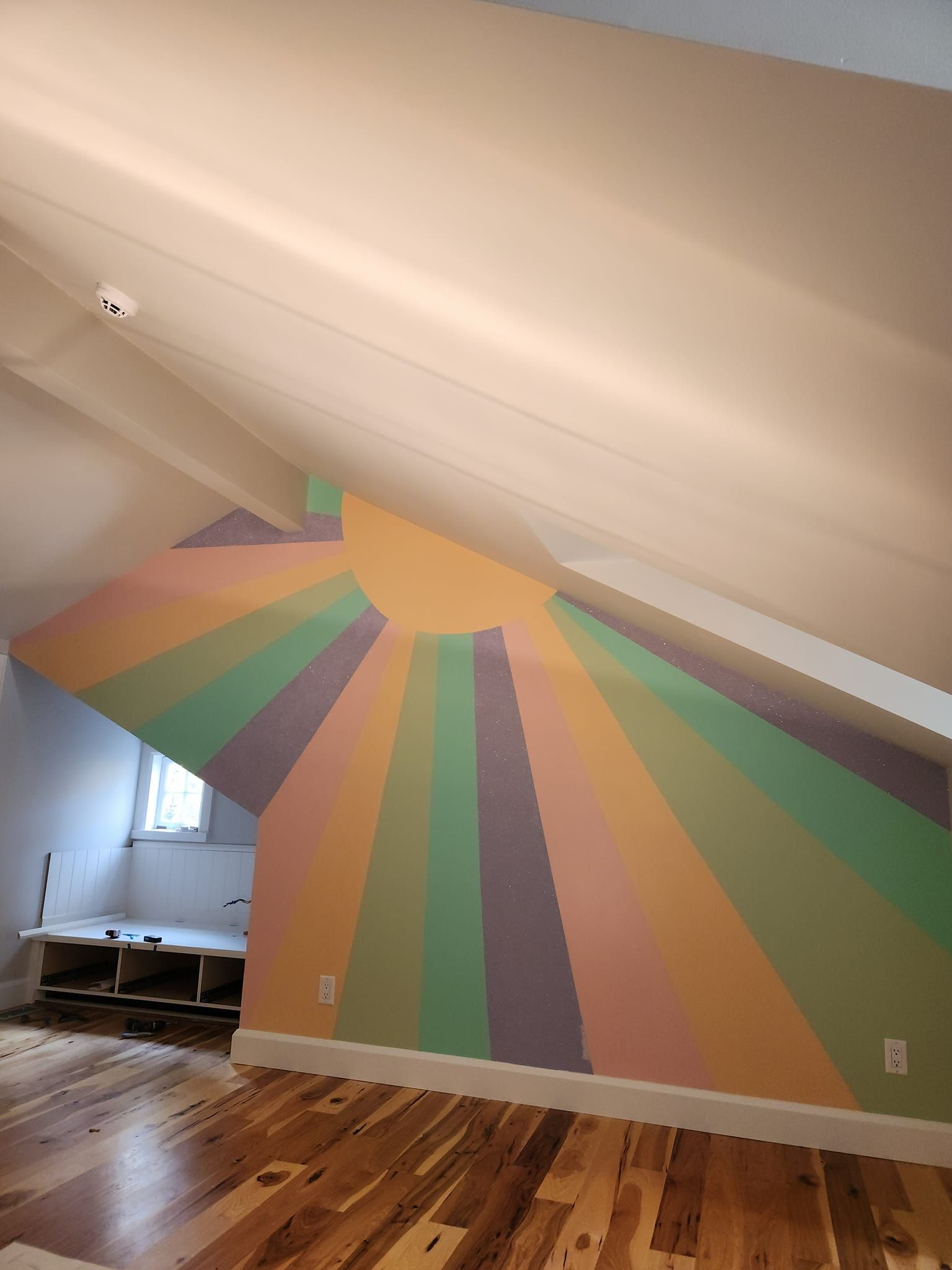 A room with a rainbow painting on the wall. artist kids room