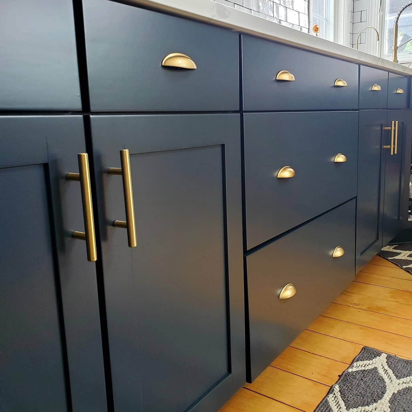 A kitchen with blue cabinets and gold handles