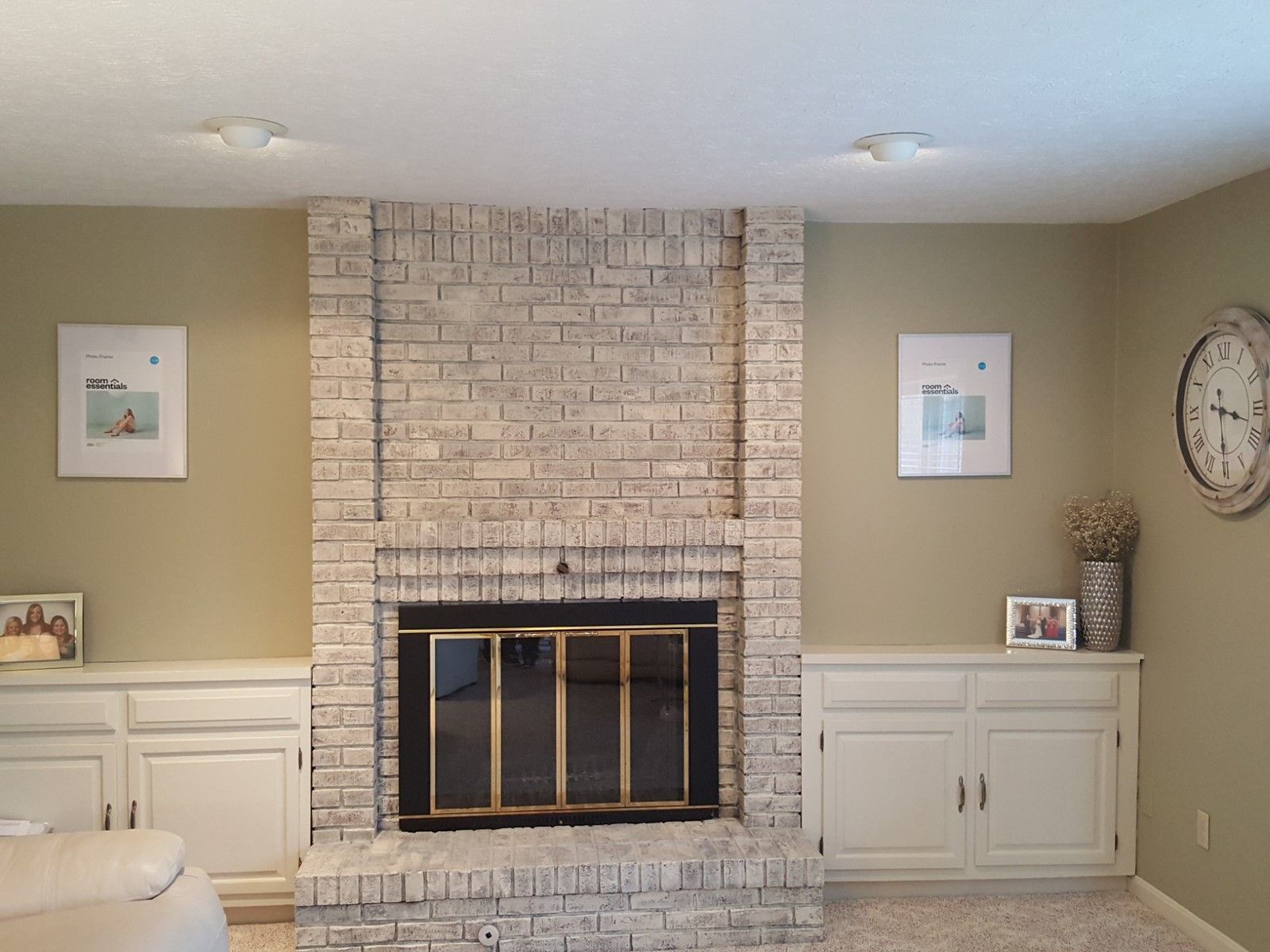 A living room with a fireplace and a clock on the wall modern