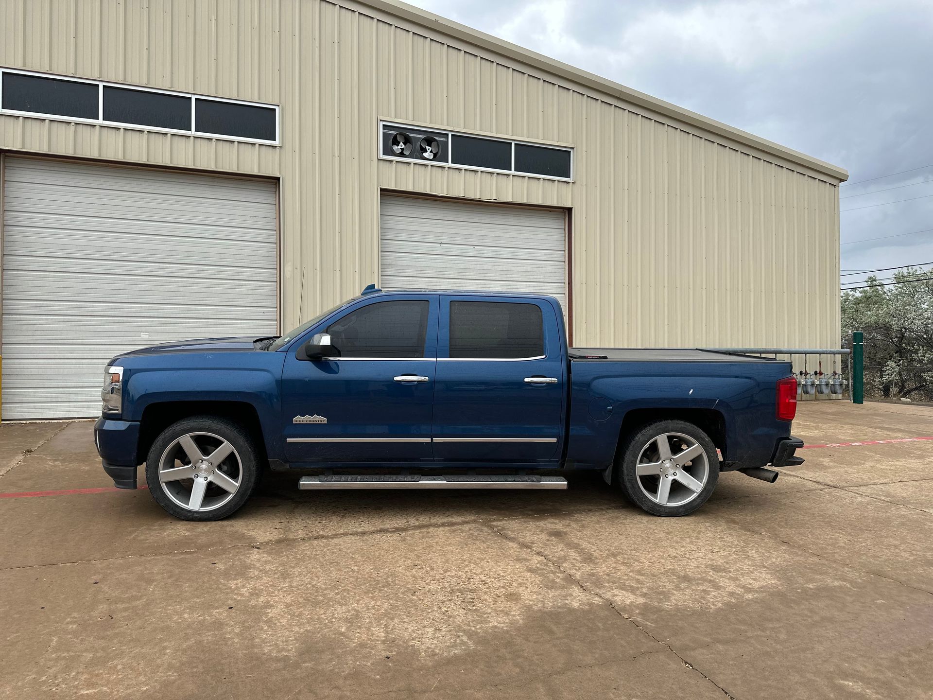 a blue truck is parked in front of a building .