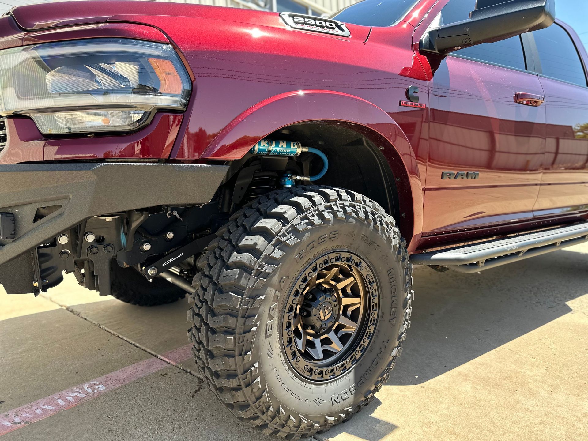 a red ram truck is parked on the side of the road .