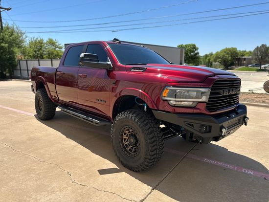 a red ram truck is parked in a parking lot .