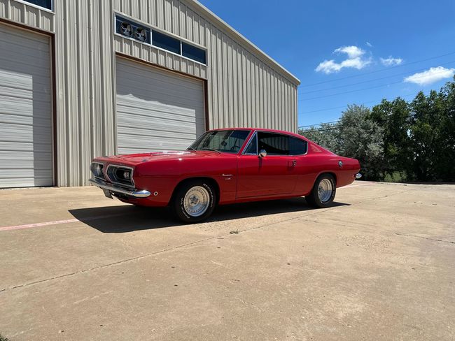 a red car is parked in front of a garage .