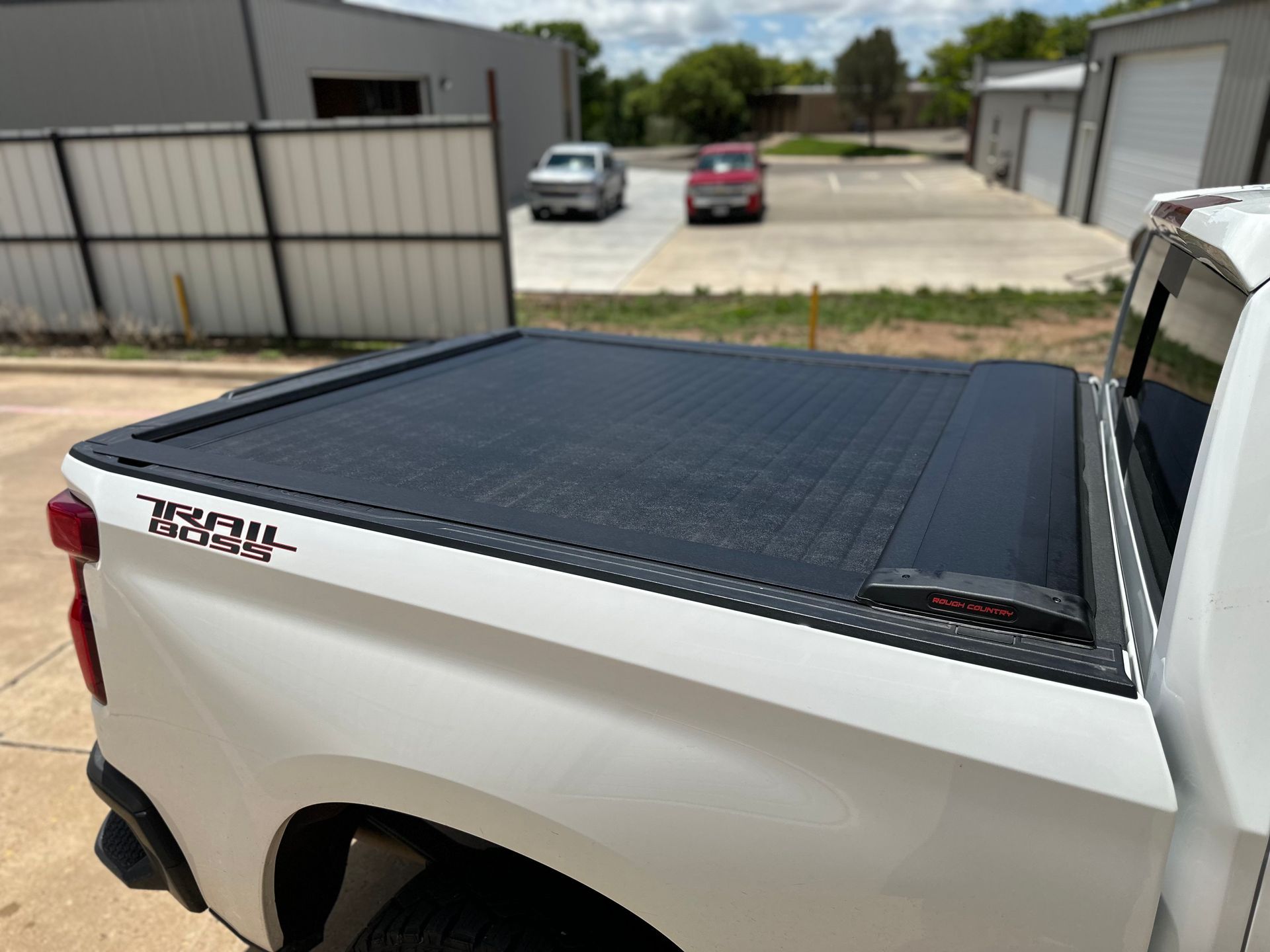 a white truck with a black tonneau cover on the bed .