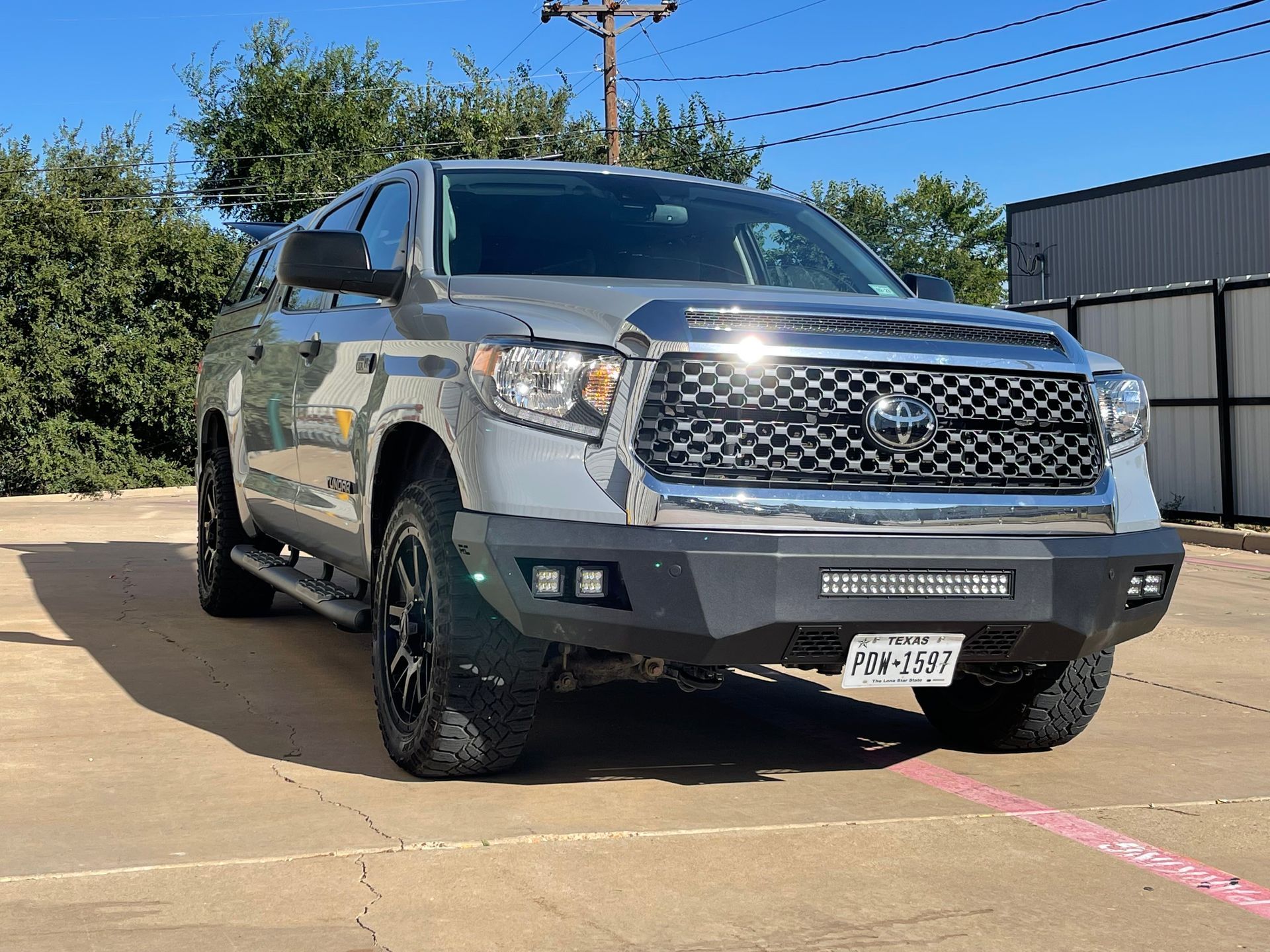 a silver toyota tundra is parked in a parking lot .