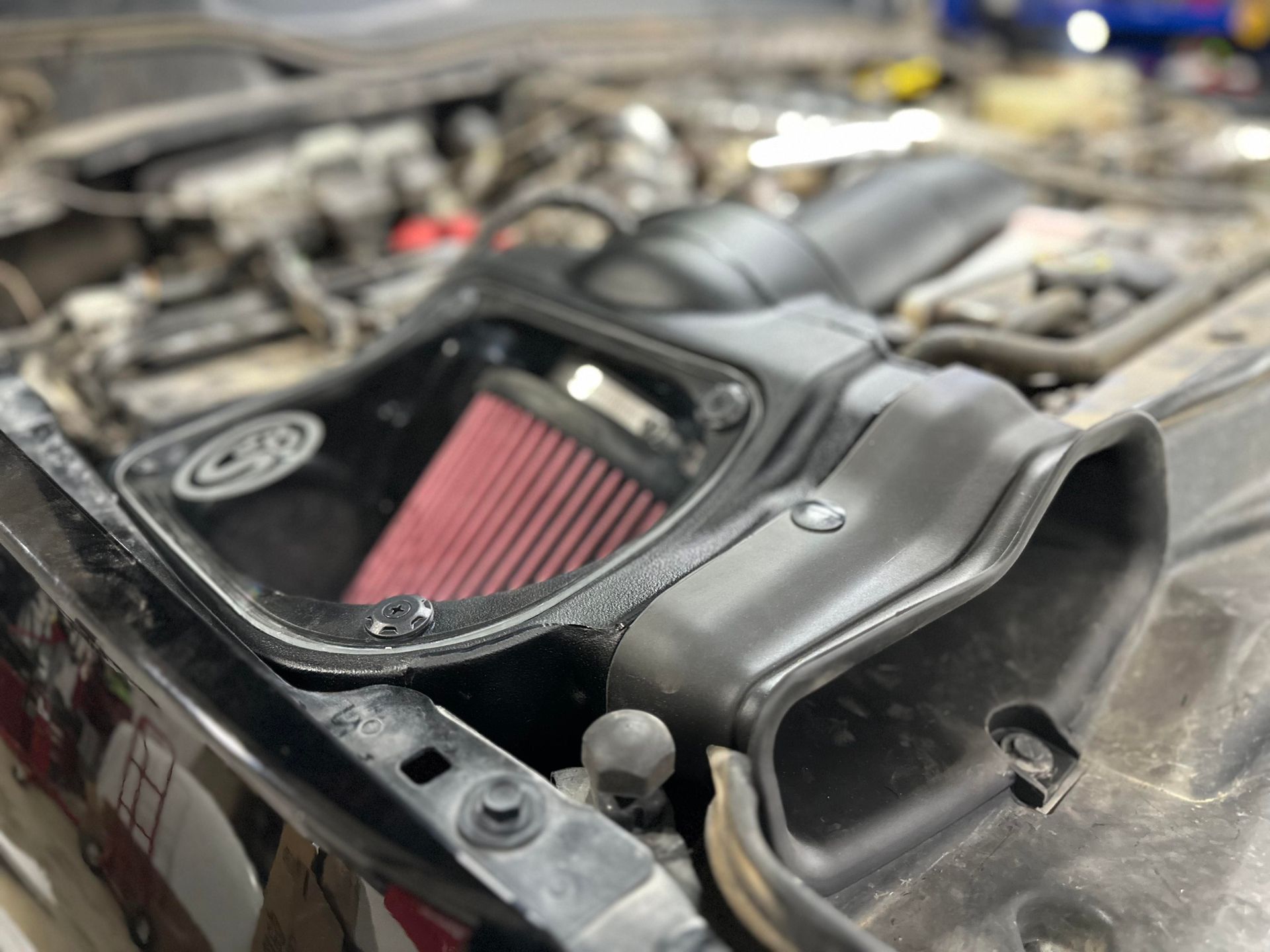 a close up of a car air filter under the hood .