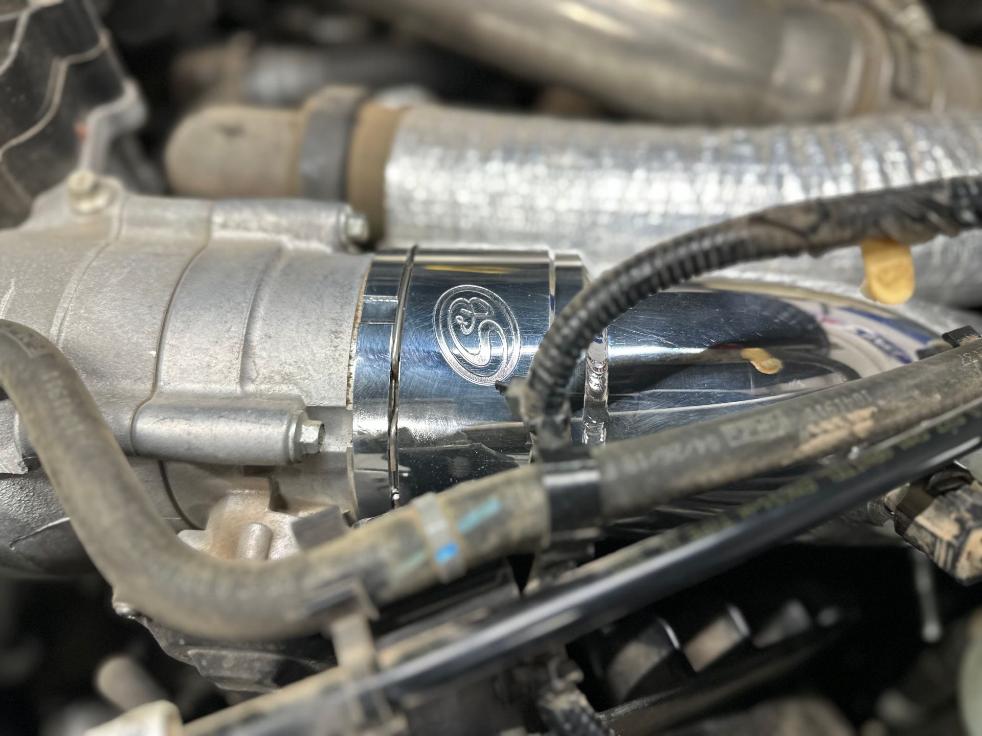 a close up of a car engine with a hose attached to it .