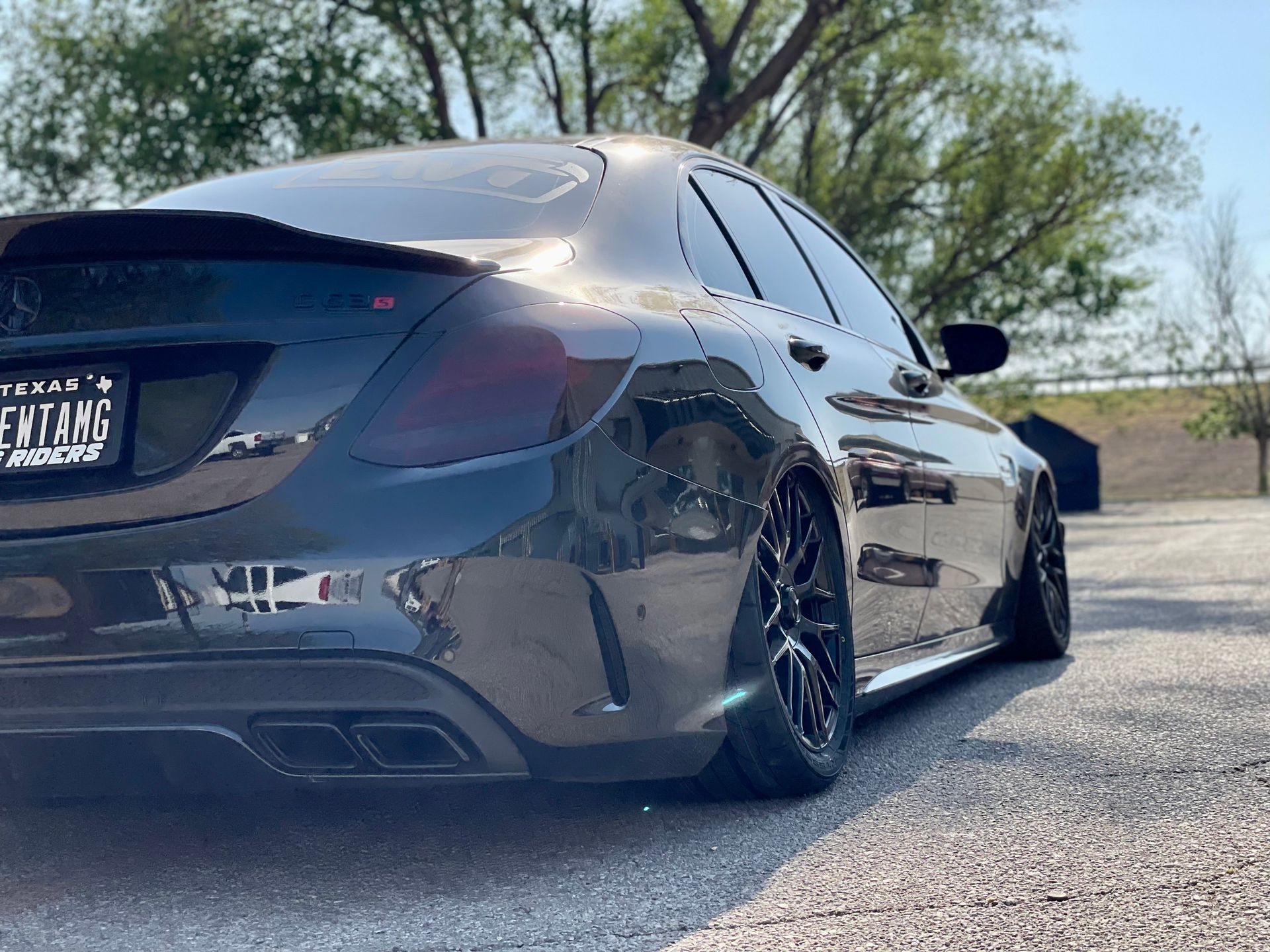 a black mercedes benz is parked on the side of the road .