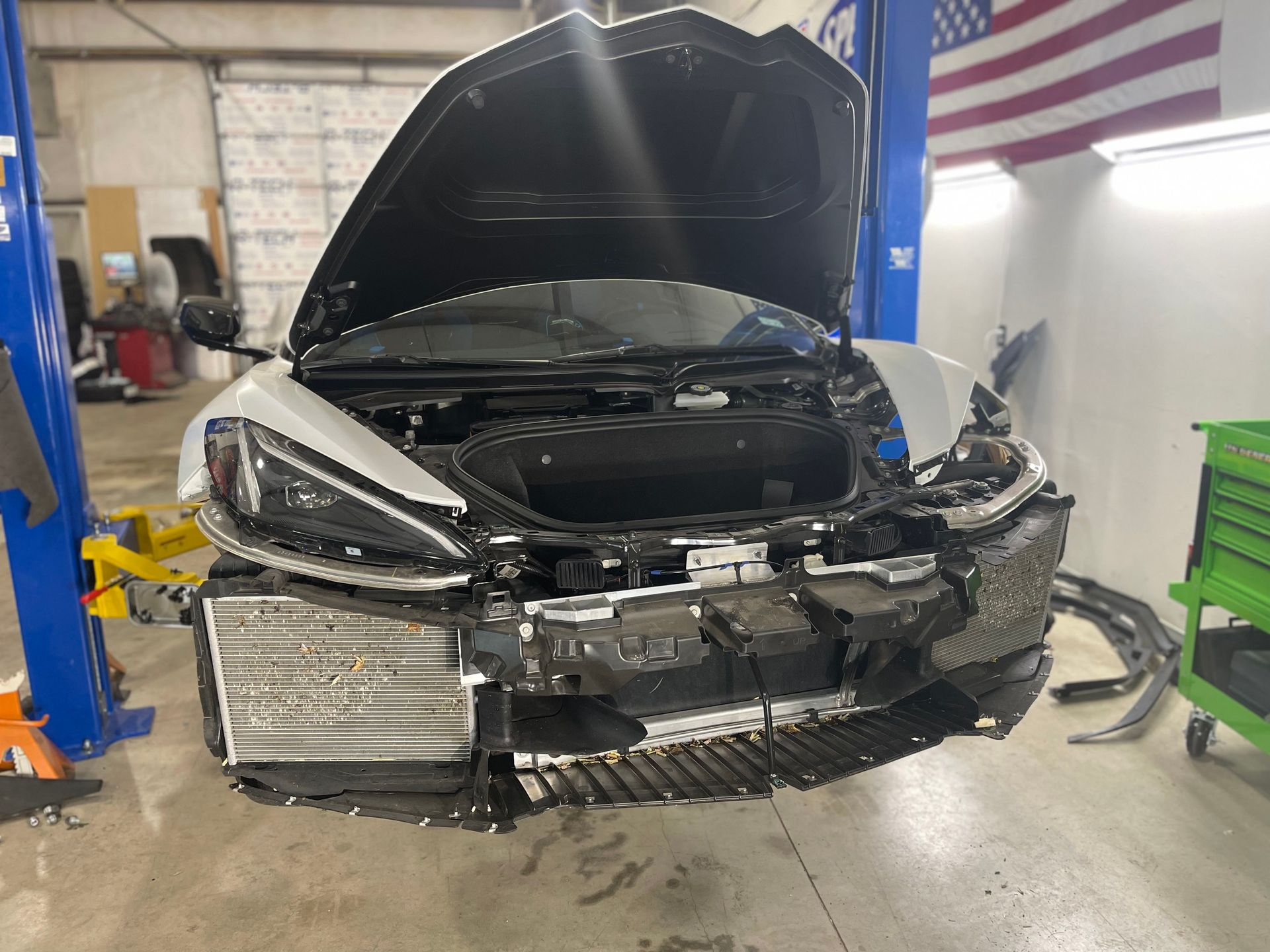 a car is sitting on a lift in a garage with the hood open .