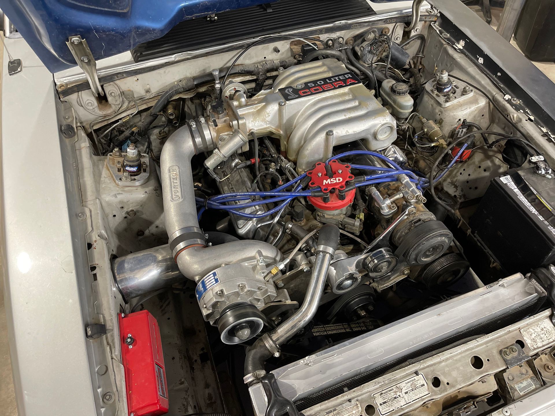 a close up of a car engine with the hood open .