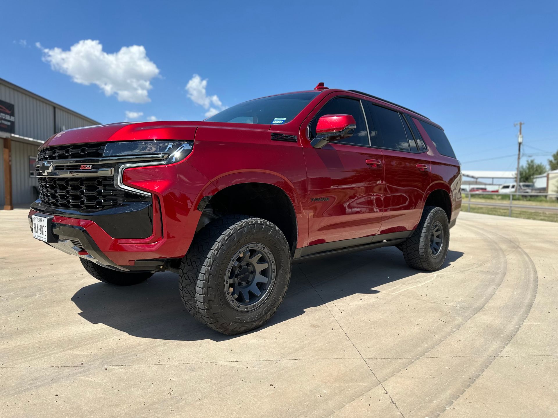 a red suv is parked on the side of a road .