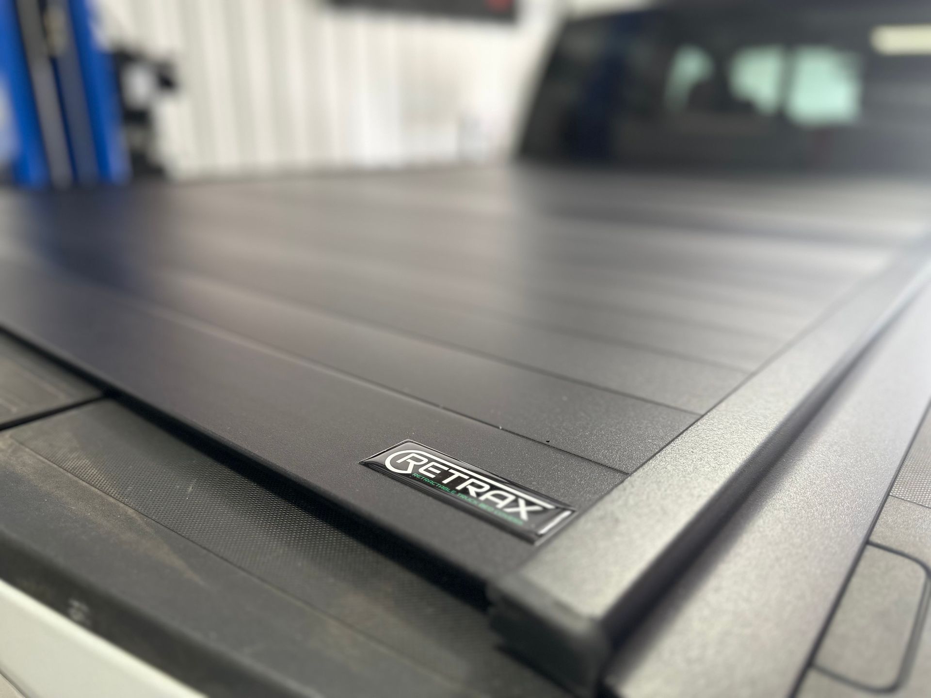 a black truck bed cover is sitting on top of a wooden table .