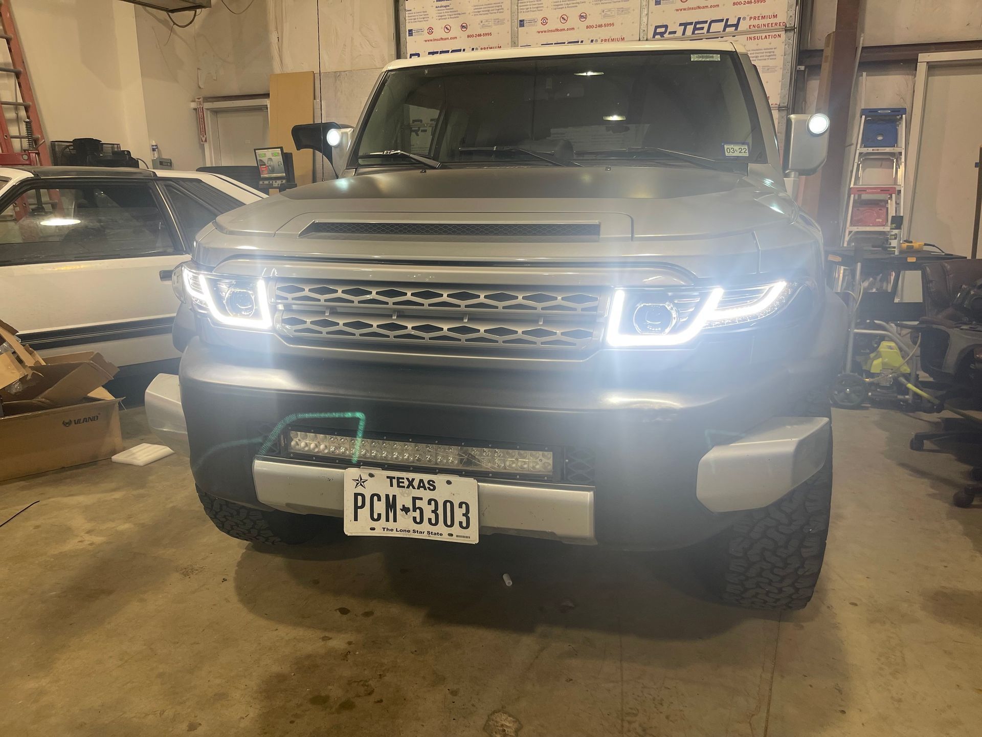 a truck with a license plate that says pcm-5303 is parked in a garage .
