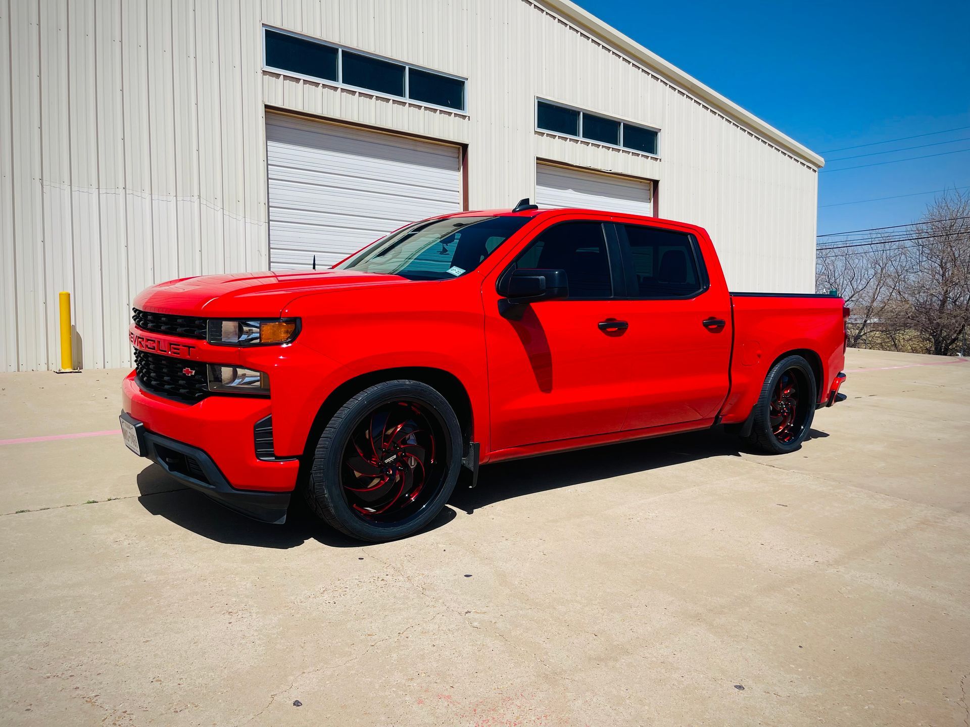 a red truck is parked in front of a white building .