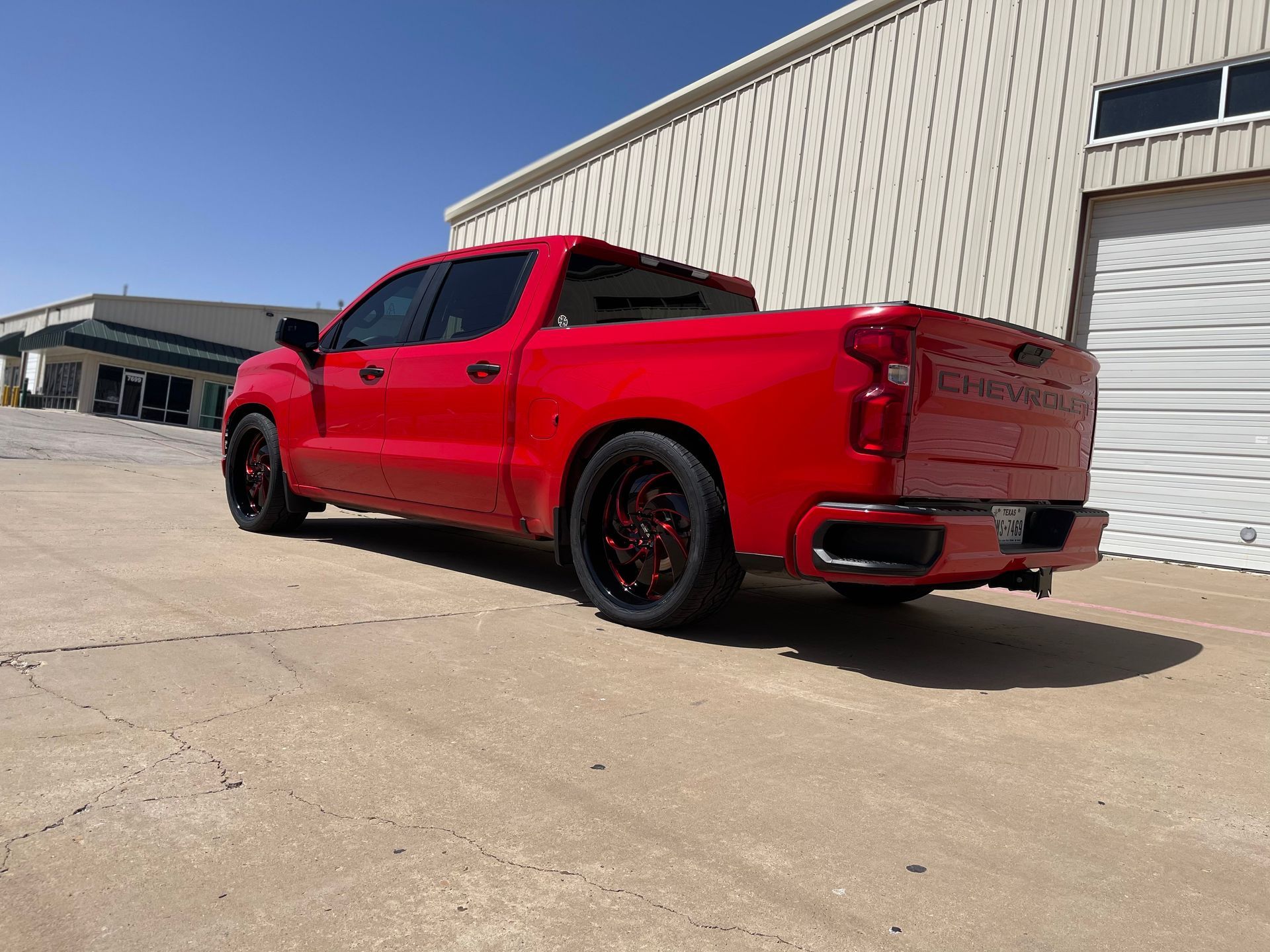 a red truck is parked in front of a building .