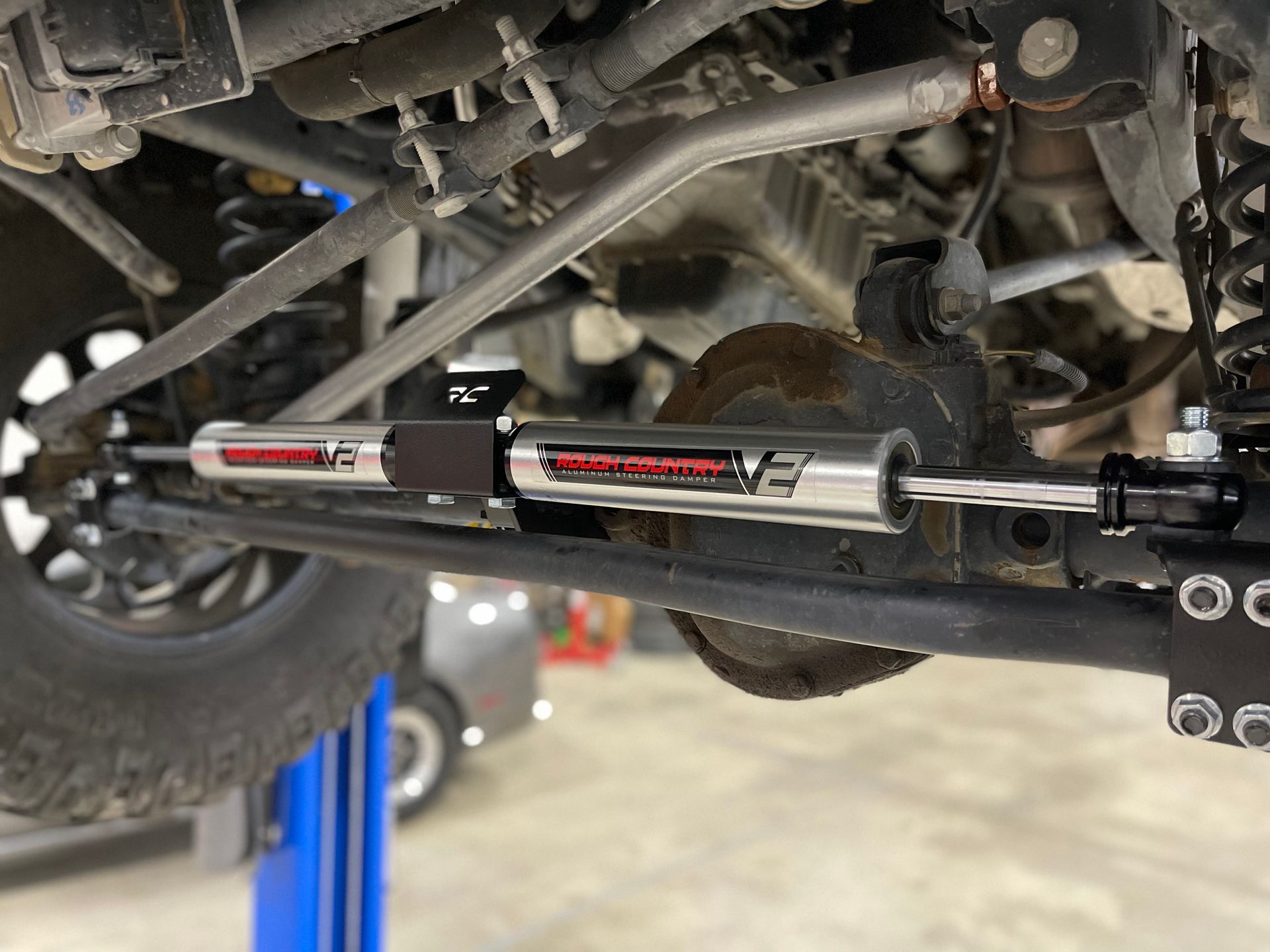 a close up of a steering stabilizer on a truck on a lift .