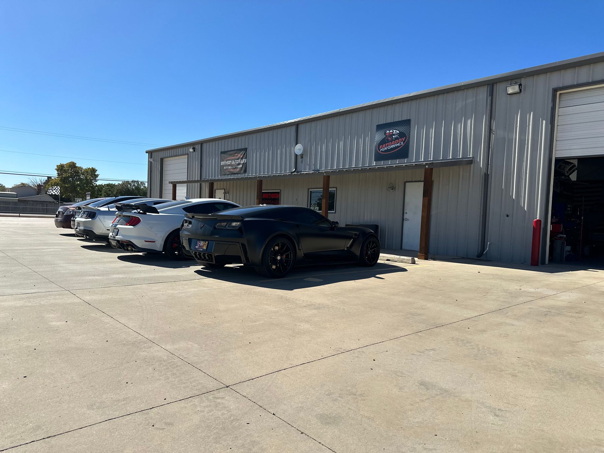a row of cars are parked in front of a building .