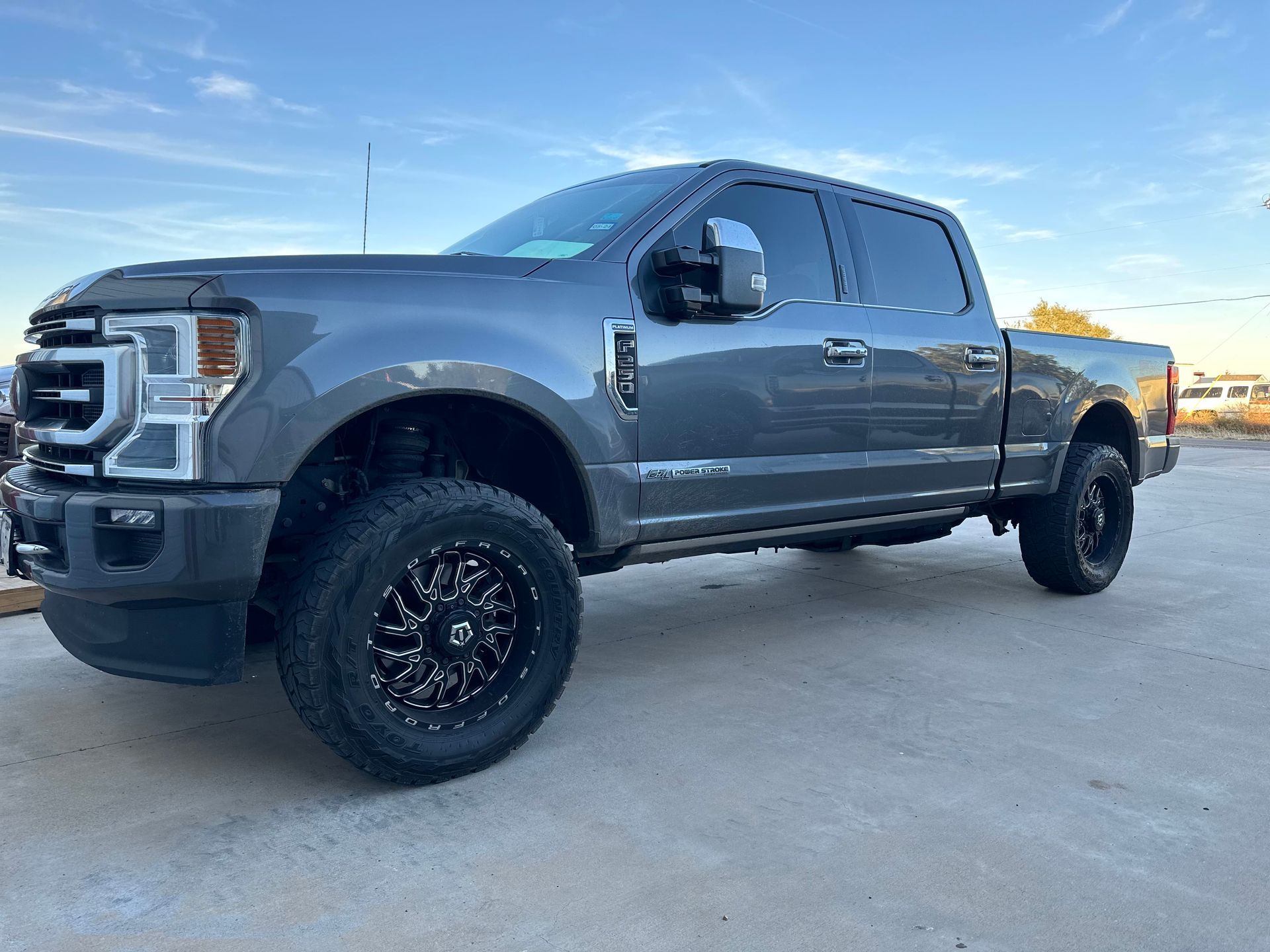 a gray ford f250 super duty truck is parked in a parking lot .