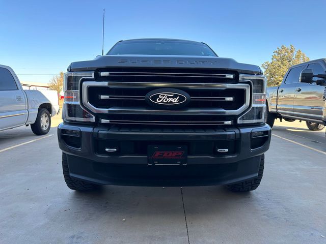 the front of a black ford truck is parked in a parking lot .