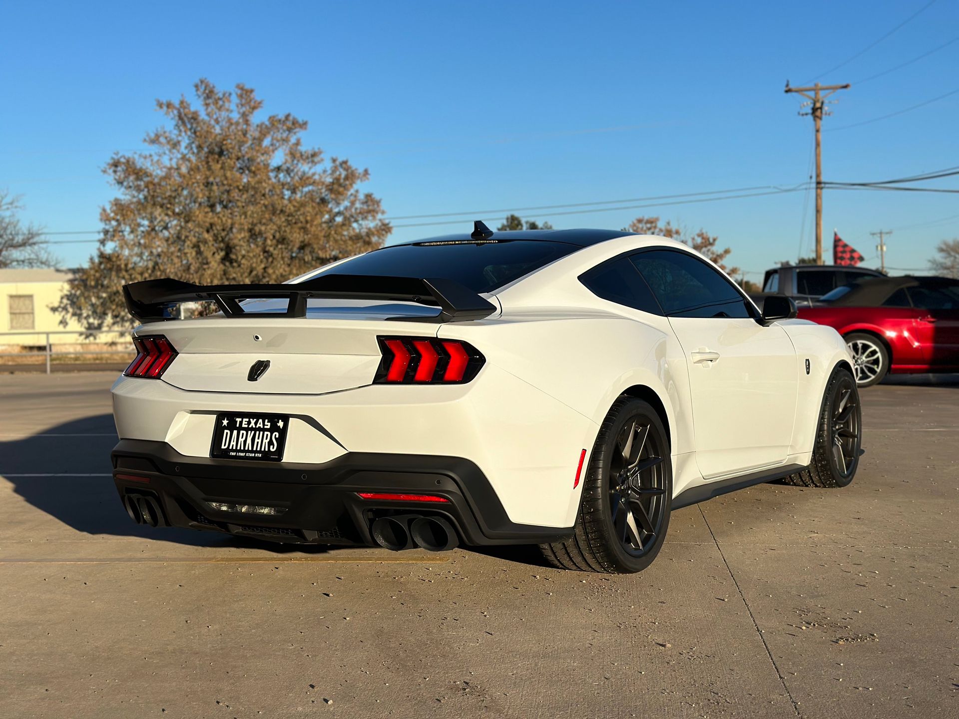 a white ford mustang is parked in a parking lot .