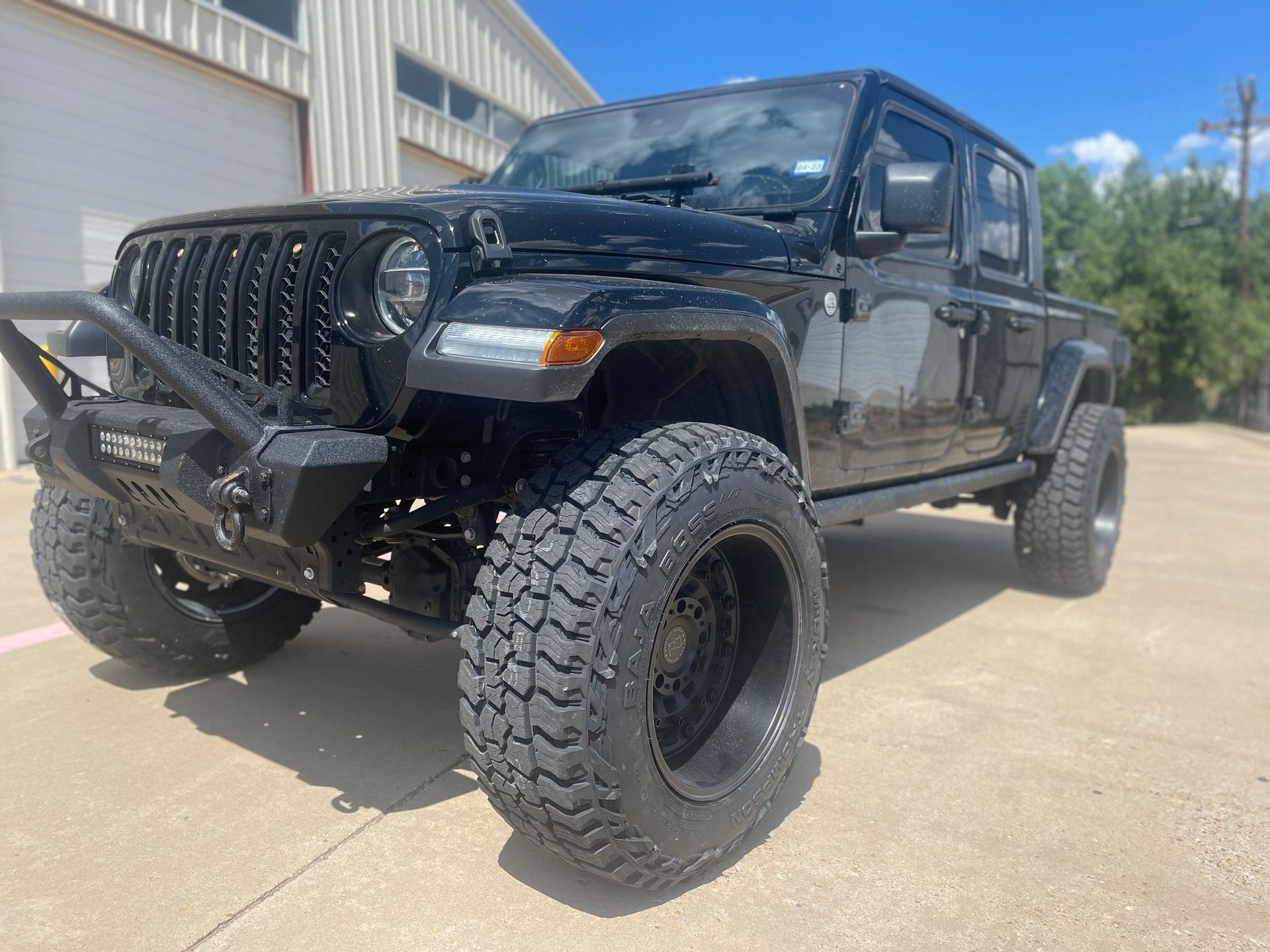 a black jeep is parked on the side of the road in front of a building .