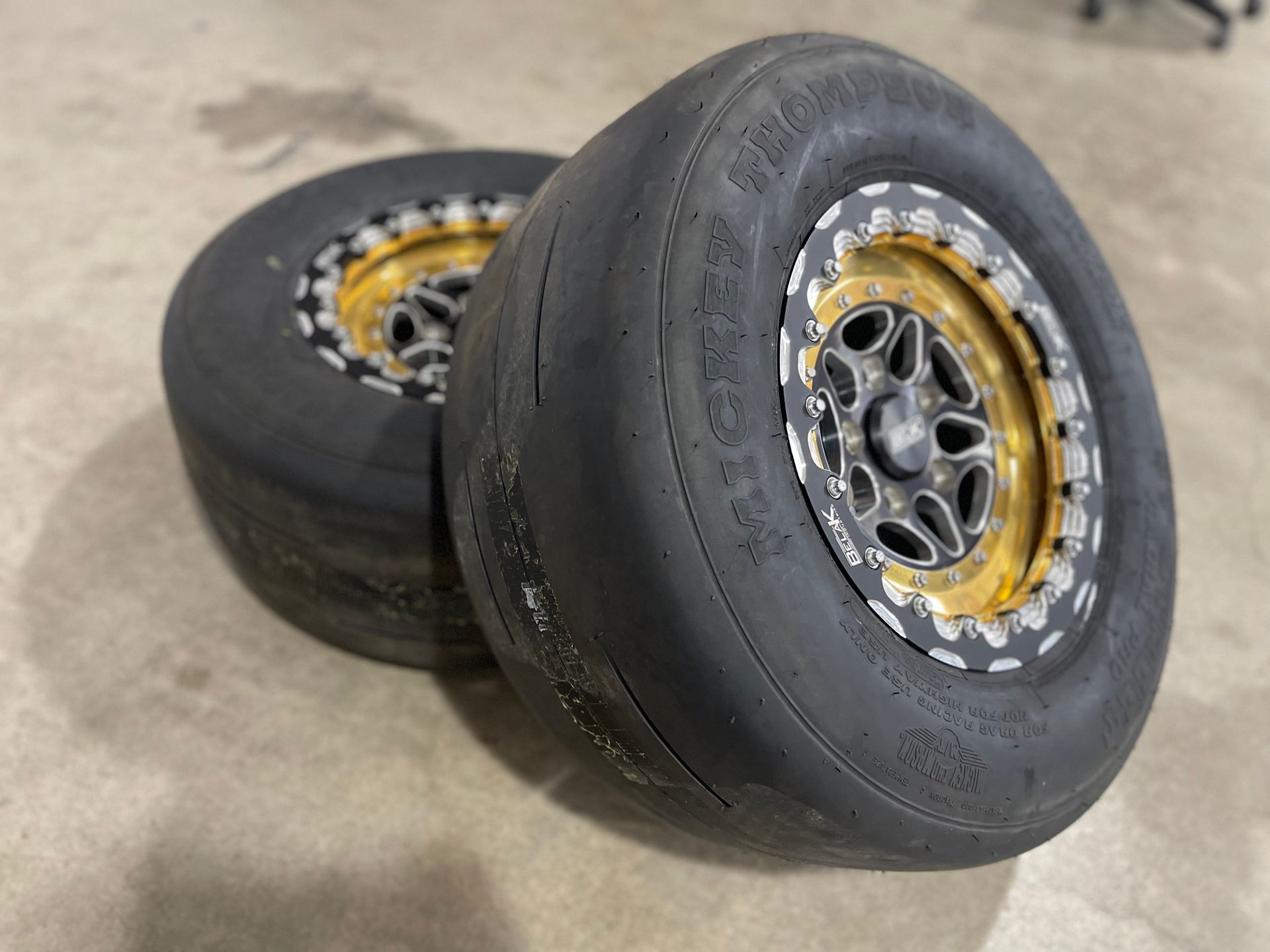 a pair of tires and wheels are sitting on a concrete floor .