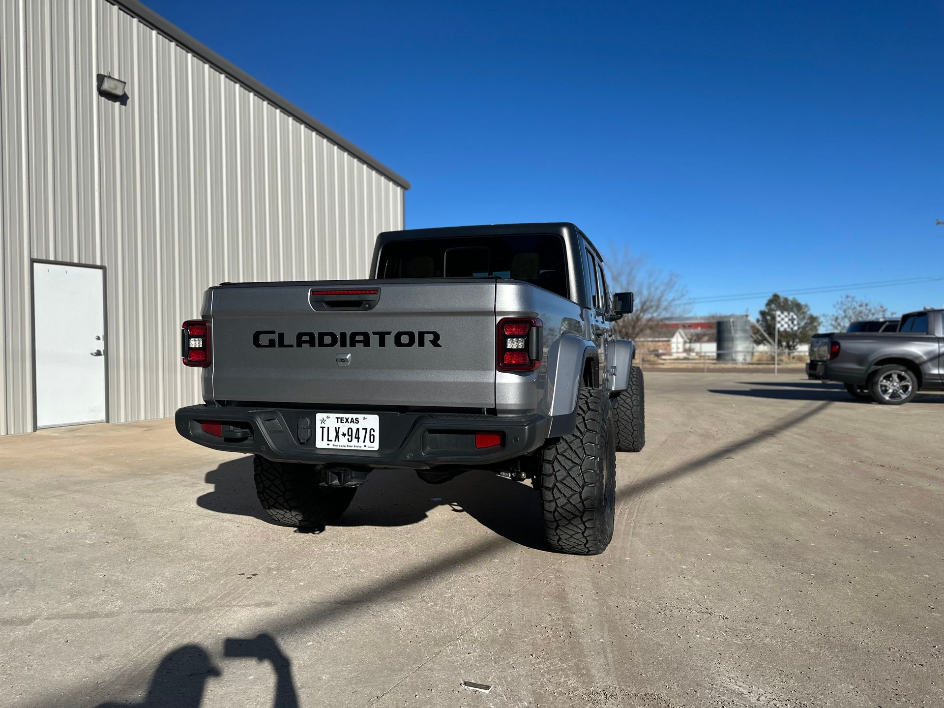 a gladiator truck is parked in front of a building .