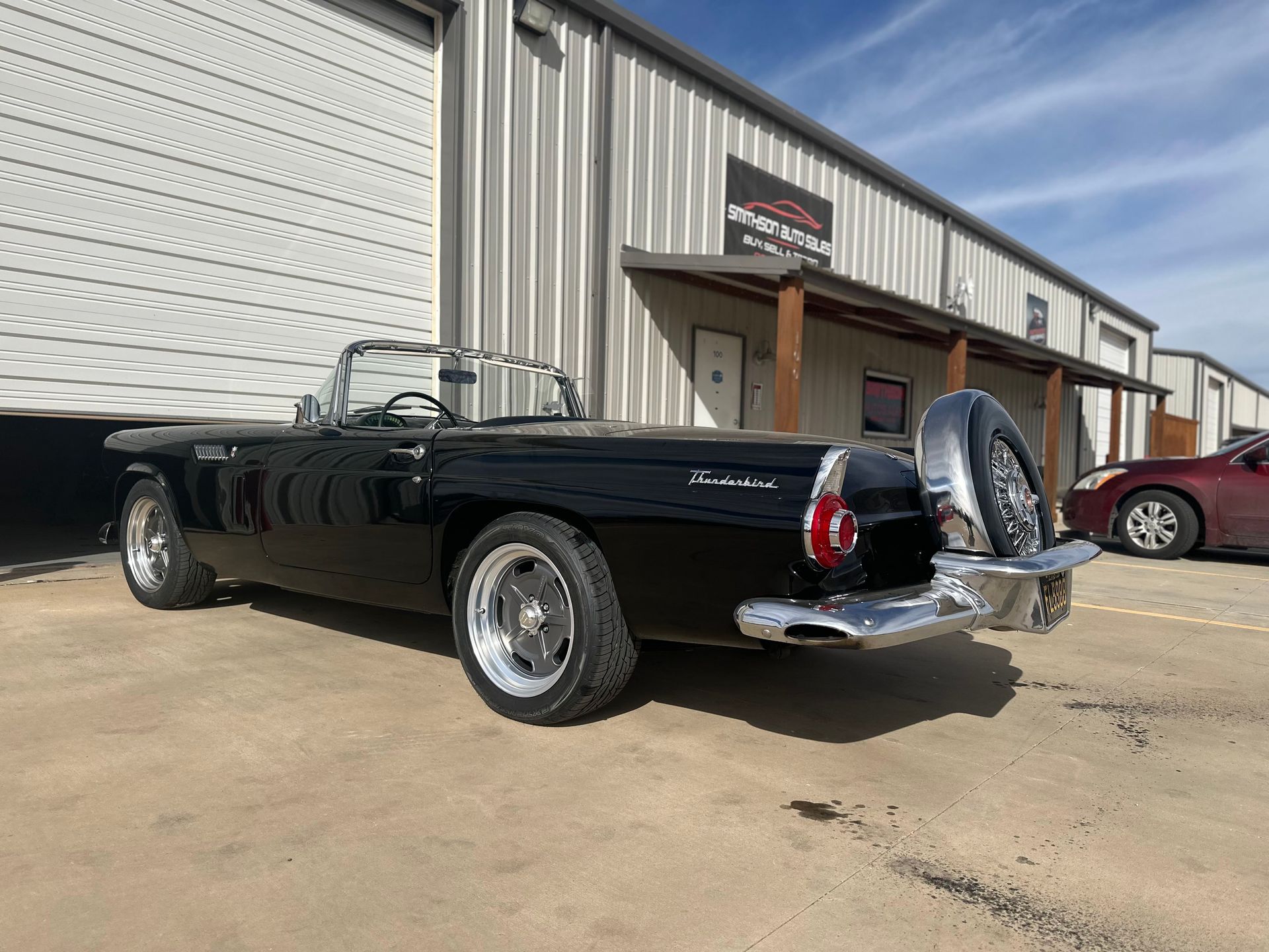 a black convertible is parked in front of a building .