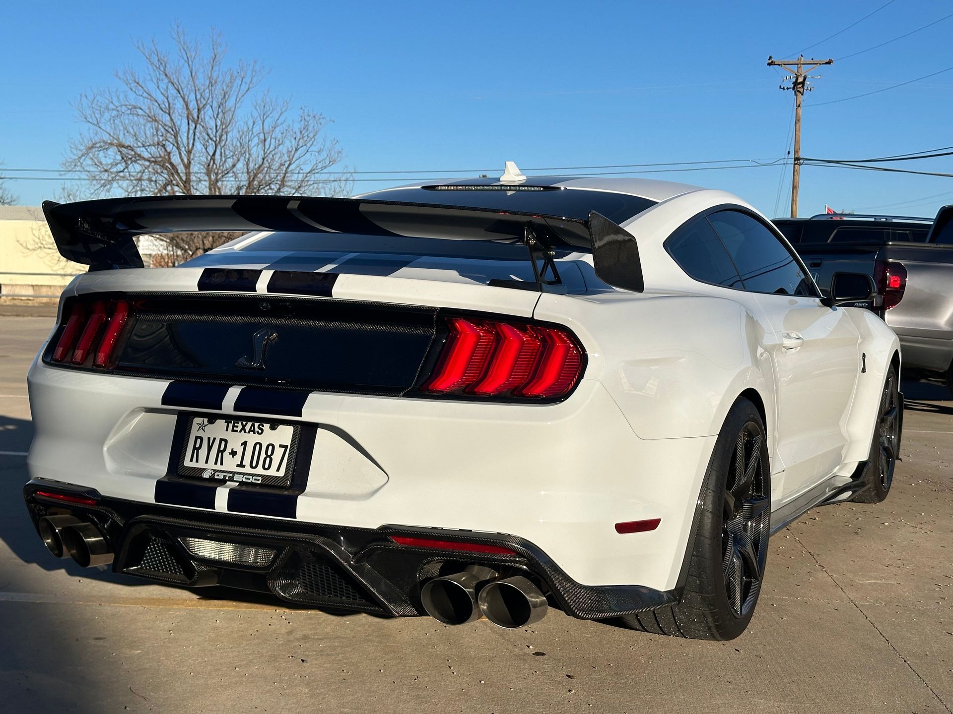 a white mustang is parked in a parking lot