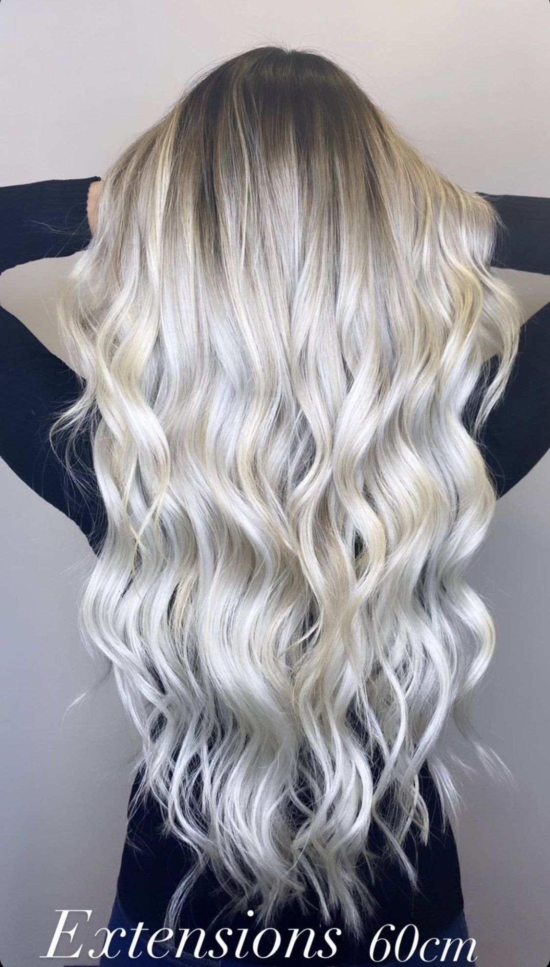 Eine Frau mit langen blonden Haaren trägt Extensions.