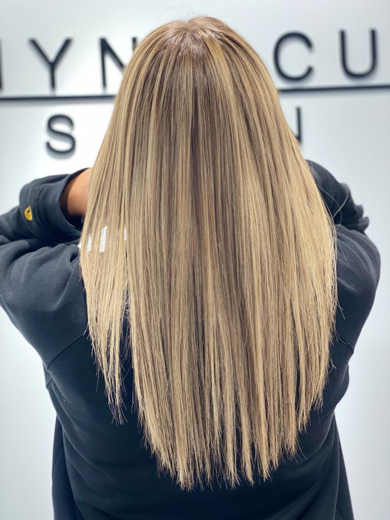 Eine Frau mit langen blonden Haaren trägt eine schwarze Jacke