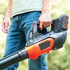Two air conditioning units outdoors with a toolbox and work gloves, near a brick wall and grass.