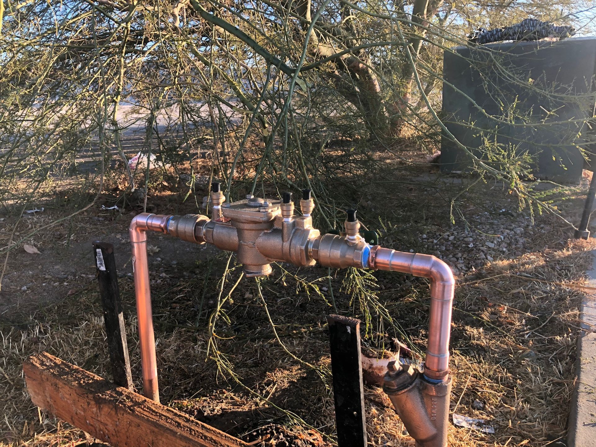 A copper pipe is sitting in the middle of a field.