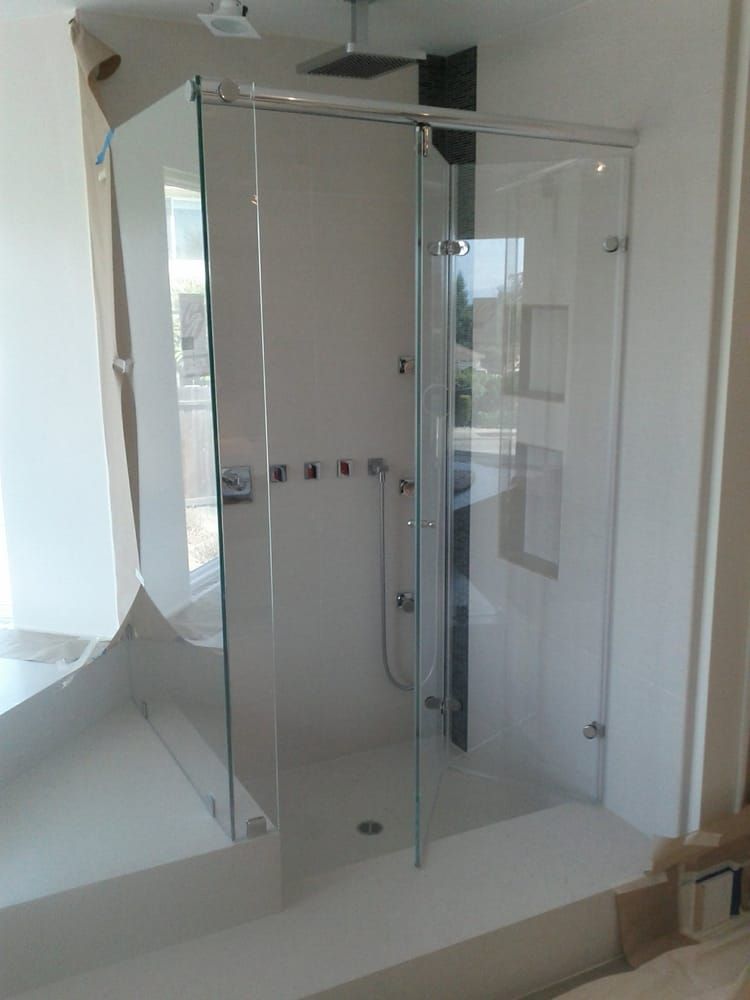 A bathroom with a sliding glass shower door.