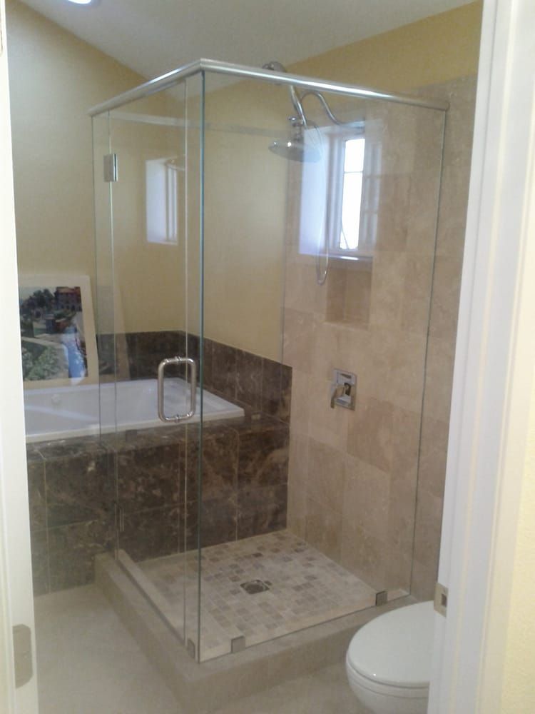 A bathroom with a walk in shower , tub and toilet.