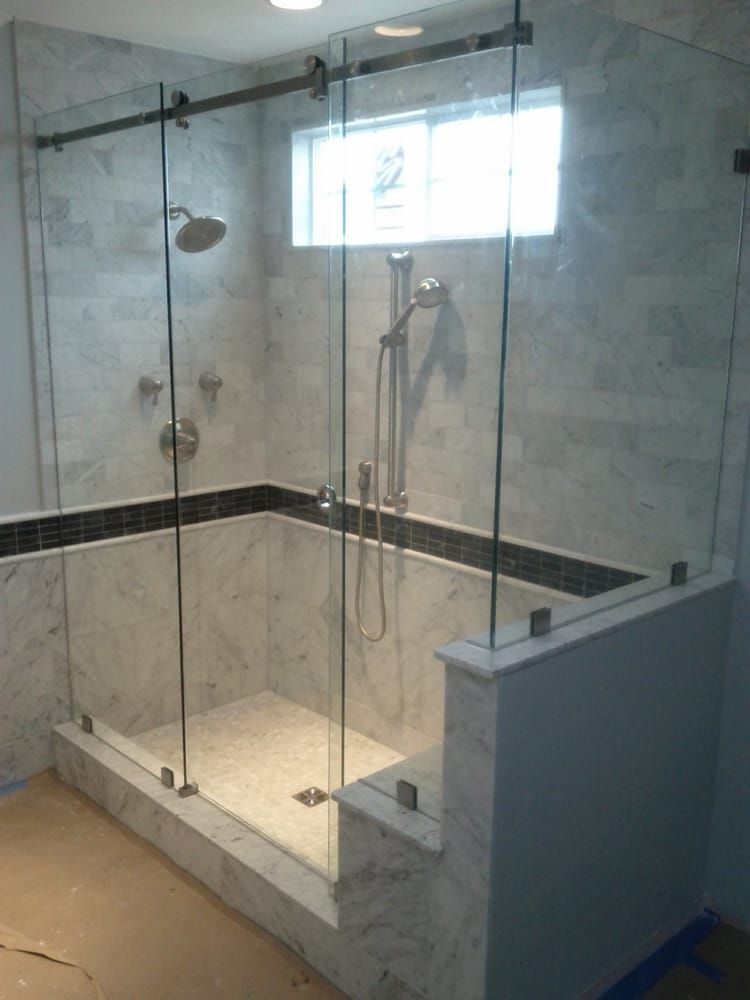 A bathroom with a sliding glass shower door and a window