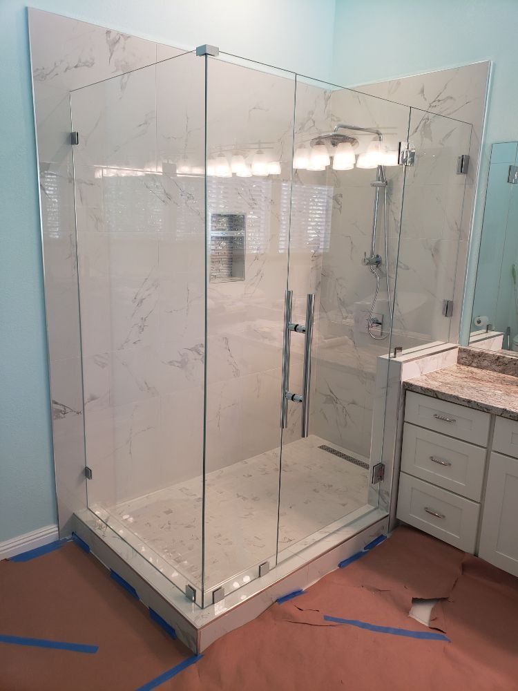 A bathroom with a walk in shower and a sink.