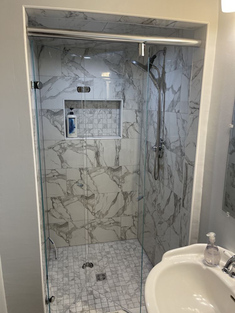 A bathroom with a walk in shower and a sink.