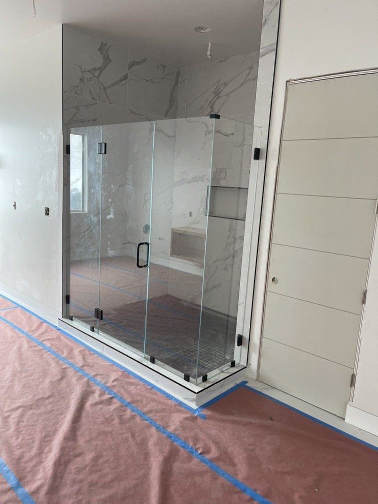 A bathroom with a shower stall and a door.