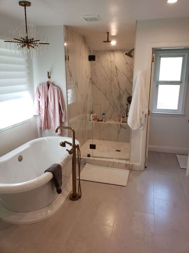 A bathroom with a bathtub and a walk in shower.