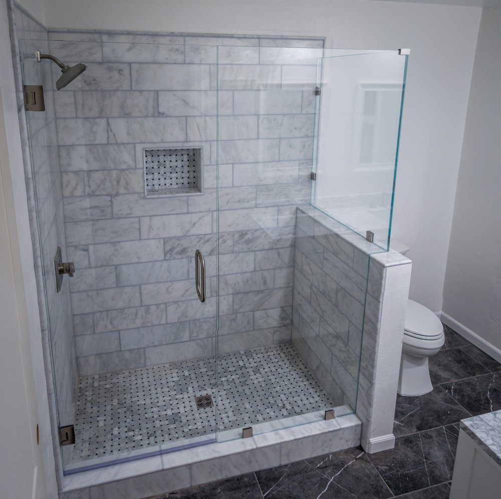 A bathroom with a walk in shower and a toilet.