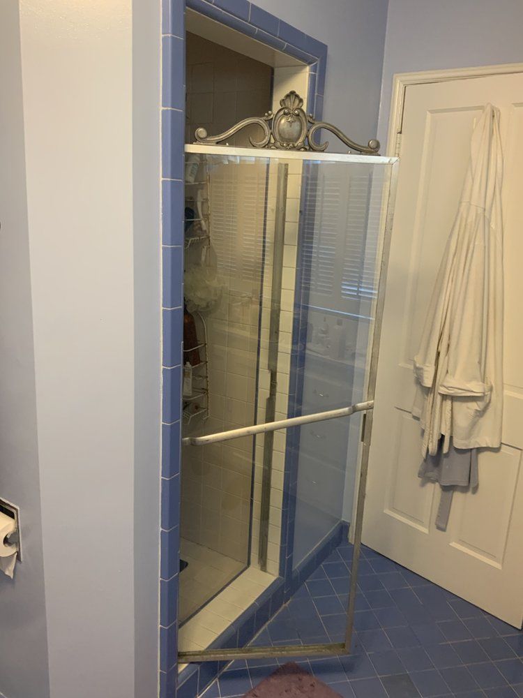 A bathroom with a shower stall and a door.
