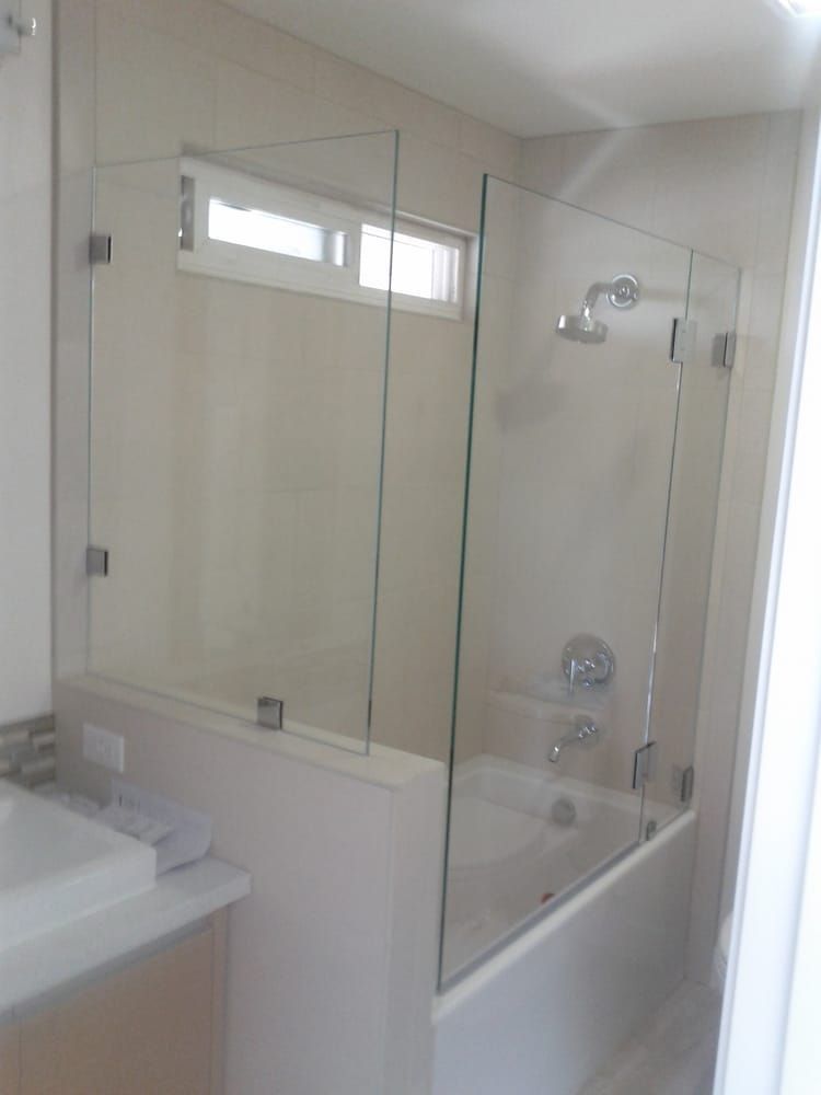 A bathroom with a bathtub and a glass shower door