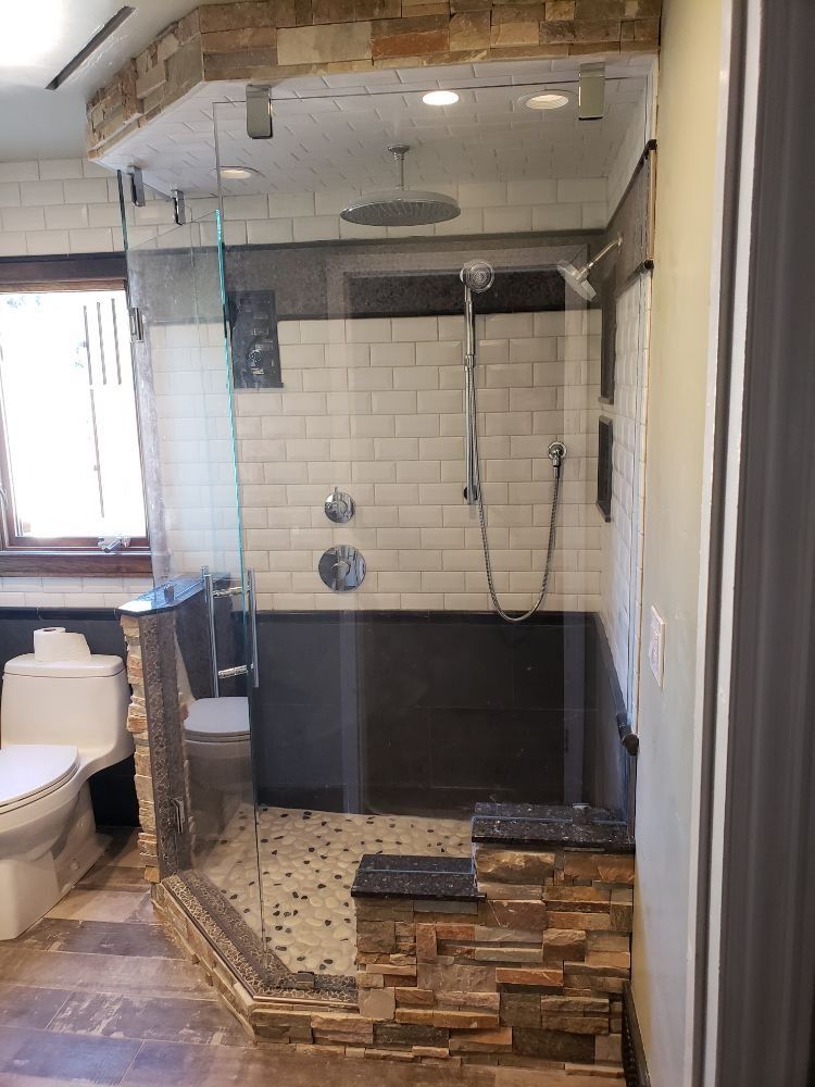 A bathroom with a walk in shower and a toilet.