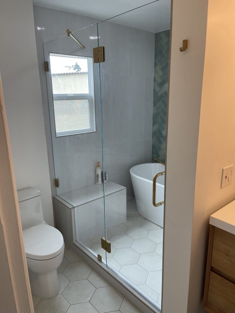 A bathroom with a toilet , shower , tub and window.