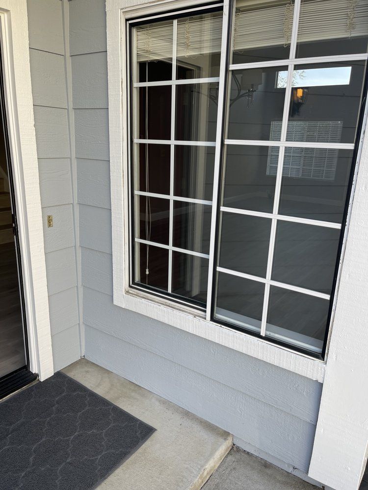 A house with a sliding glass door and a large window.