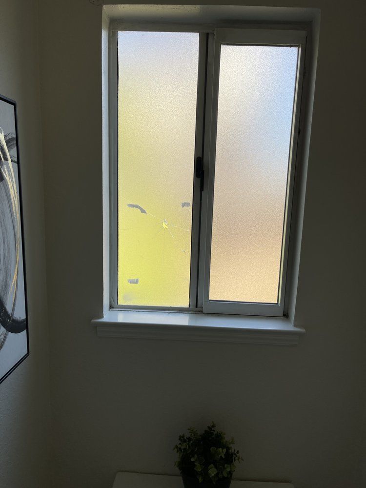 A window with a picture on the wall behind it