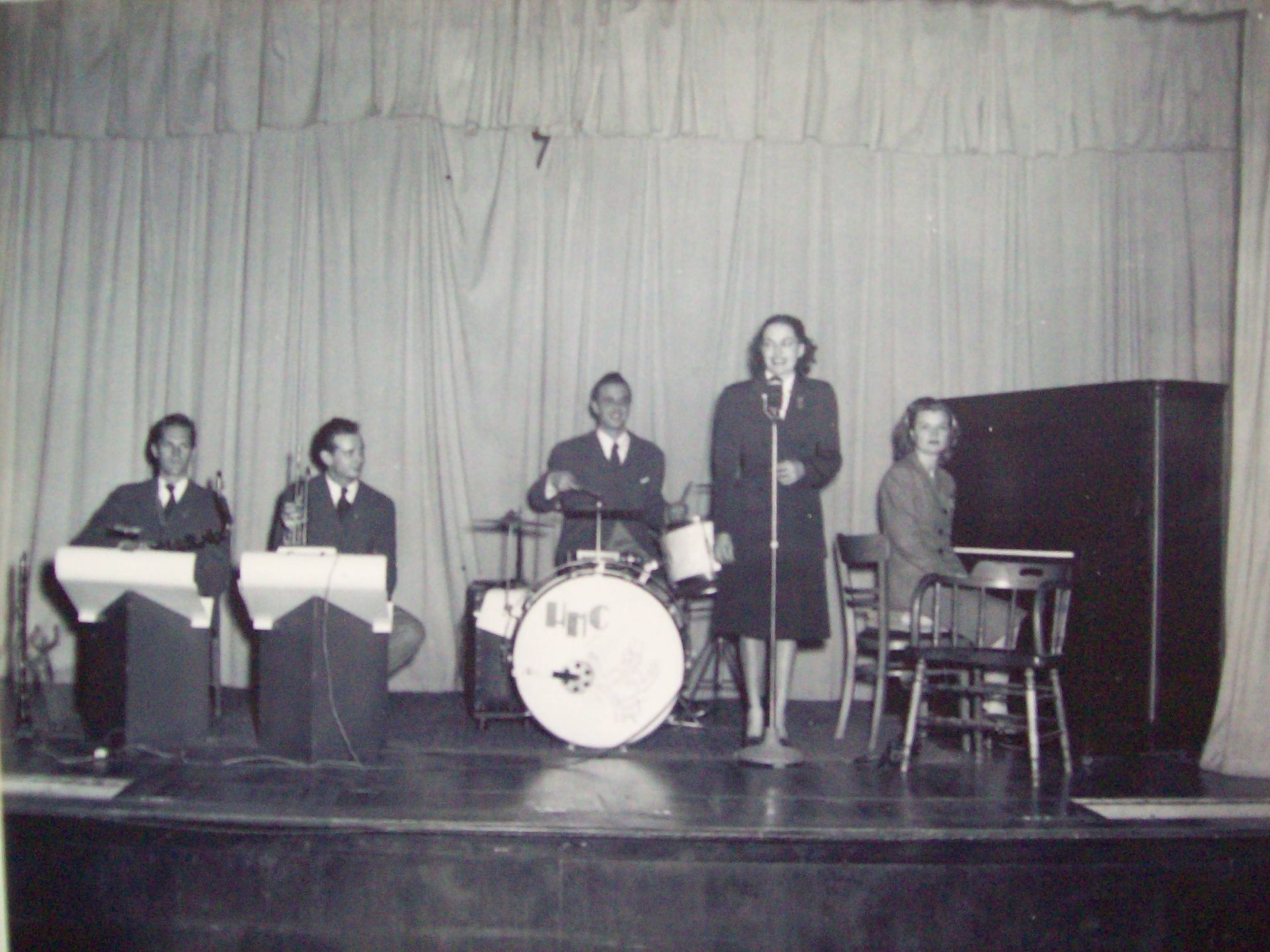 A black and white photo of a band with a drum that says tpt on it